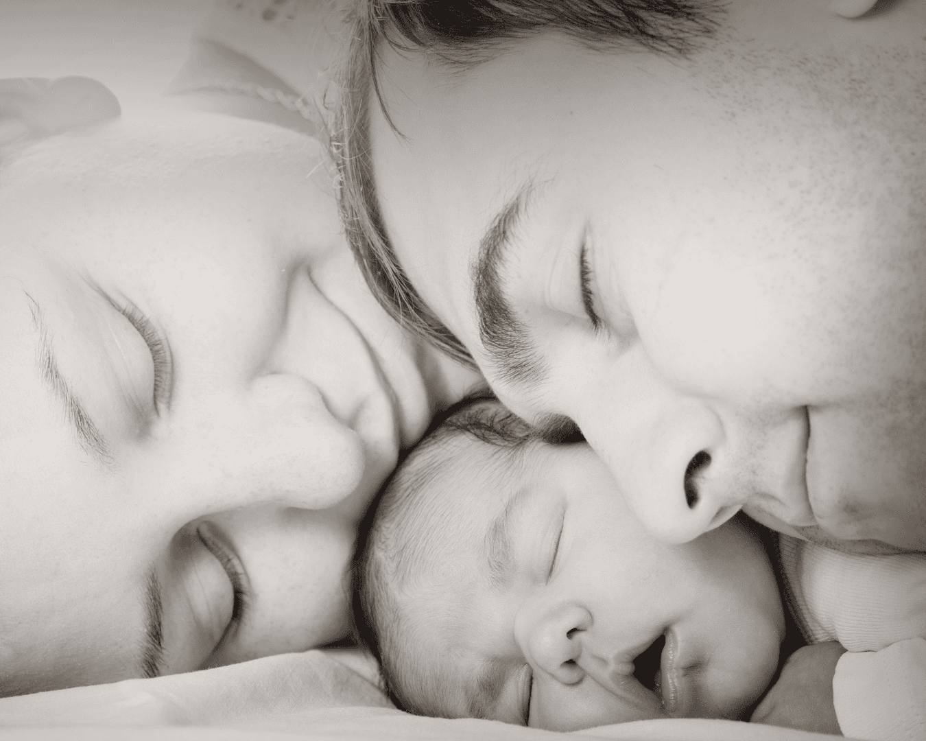Happy family sleeping with baby